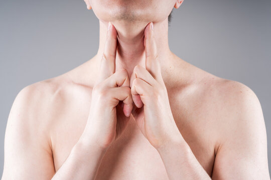 Unrecognizable man checking swollen lymph nodes on his neck, sore throat and cold medical concept