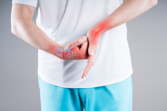 Pain in hands of man, with illustration anatomical joint, bones, nerve and red backlight. Concept treatment arthritis and inflammation wrist joint
