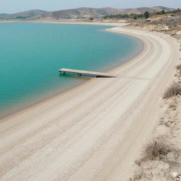 tranquil deserted beach with crystal clear turquoise waters and wide sandy shores during a sunny day