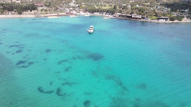 Aerial Drone View of Turquoise Bay with Anchored Boat and Sandy Coastline in Cesme Izmir Turkey 4K