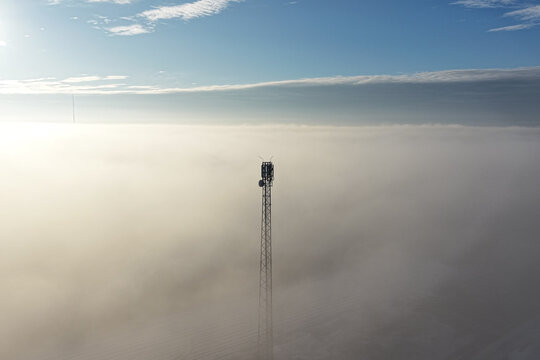 Network transmission tower in minimal foggy landscape