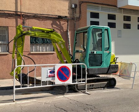 Maquinaria industrial. Vista lateral de una mini excavadora Yanmar detr&aacute;s de una valla de obra en Madrid, Espa&ntilde;a, 30 de mayo de 2026