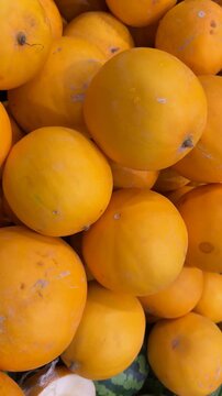 Bright orange cantaloupes piled together creating a vibrant background texture