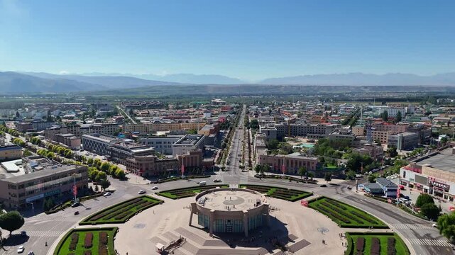 Drone Slowly Pull Back and Ascend, Overhead View of Tekes Bagua Eight Diagrams City Square, Xinjiang China Sunny Day with Distant Tianshan Mountains