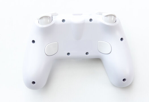Back view of a white video game controller on white