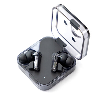 Modern wireless transparent earphones inside an open charging case
