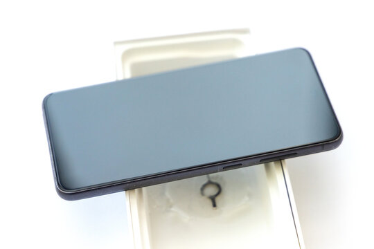 Unboxing a new smartphone with white packaging background