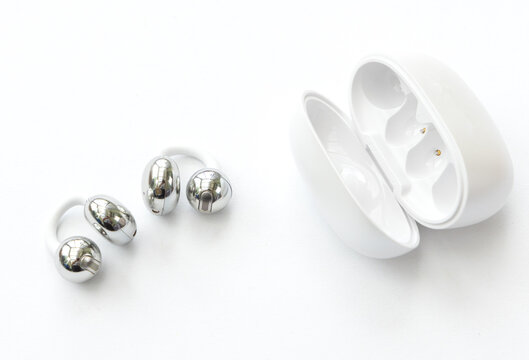 Modern wireless silver open ear earbuds with charging case