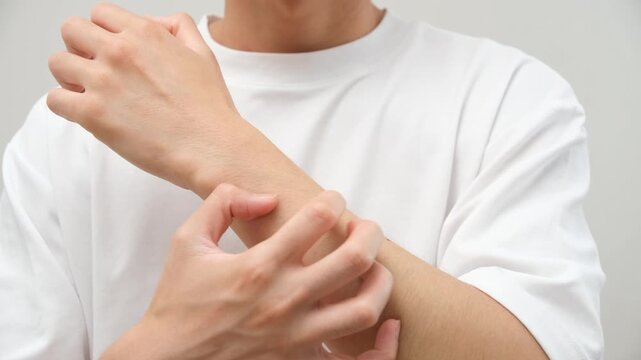 腕の痒みに悩む男性と白背景