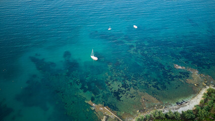 Sailboats anchoring in the transparent turquoise water near the rocky coastline of castellammare del golfo. Sicily. Showcasing vibrant marine life and promoting themes of summer. Travel © DusanJelicic