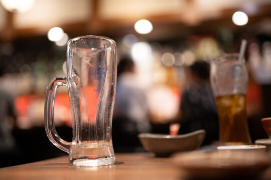 居酒屋のテーブルに置かれた飲み終えた空のジョッキ