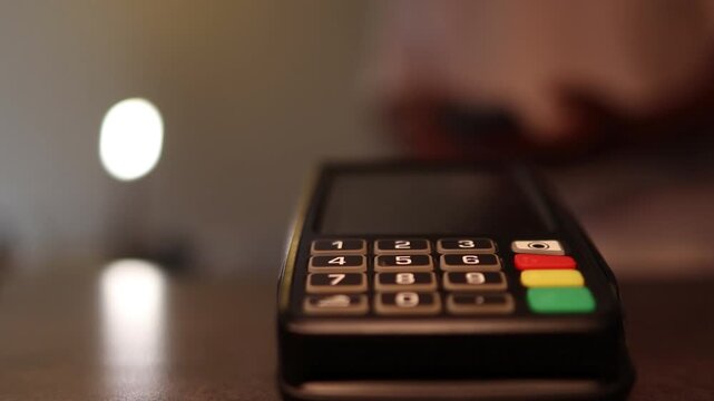 Customer using contactless credit card for electronic payment on a pos terminal in a store for a secure transaction