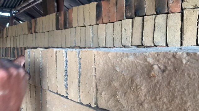 Worker Manually Arranging Raw Bricks Before Firing