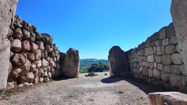 Two carved stone lions guard the ancient entrance portal of the Lion Gate set within cyclopean walls at Hattusa.