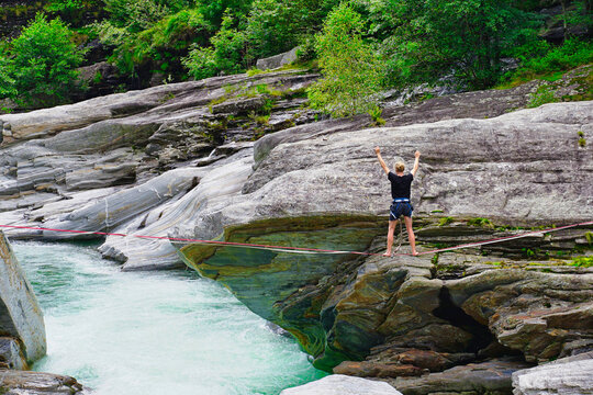 Tightrope walker over the turbulent waters of the Verzasca River, Tessin, Switzerland