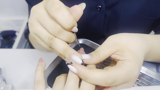 Manicurist drawing black french tip nail art design close up 16:9, beauty salon manicure fashion concept