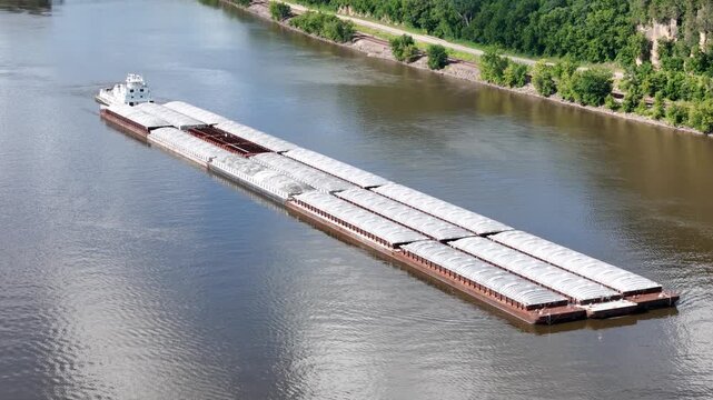 Tug boat pushing a large set of barges South down  the Mississippi River