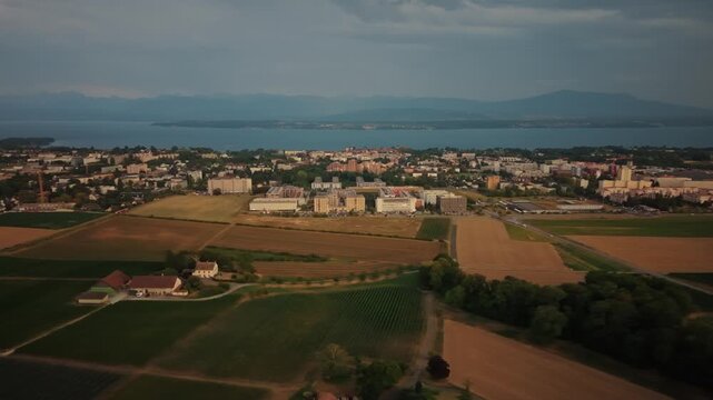 Aerial view of the town of Nyon with surrounding agricultural fields and Lake Geneva in the background in Nyon, Vaud, Switzerland.