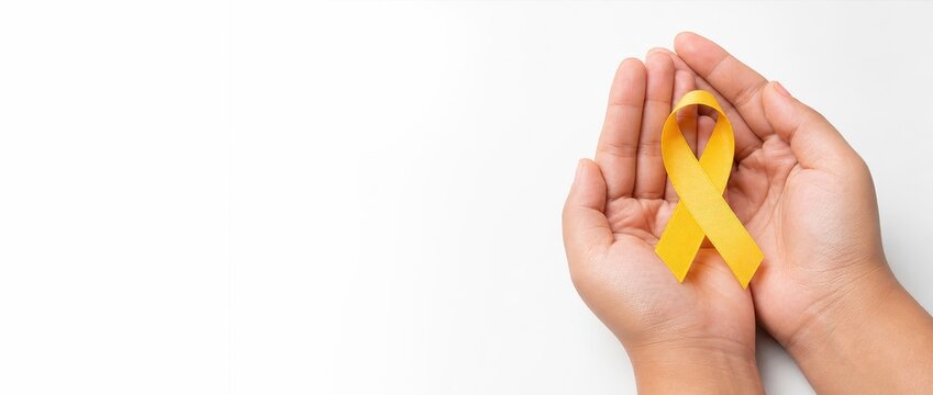 Hand holding yellow ribbon for awareness on white background banner