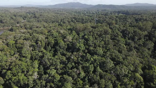 Aerial view of the lush tropical rainforest canopy and the cableway line in Kuranda, Queensland, Australia.