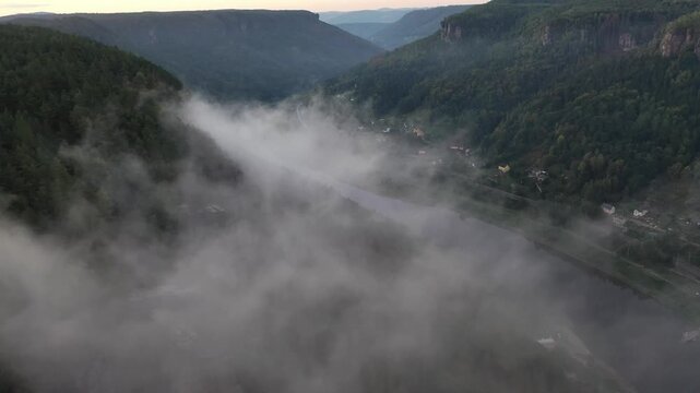 Aerial view of Belvedere Viewpoint surrounded by dense forests and morning mist in the Elbe Sandstone Mountains in Decin, Usti nad Labem Region, Czechia.
