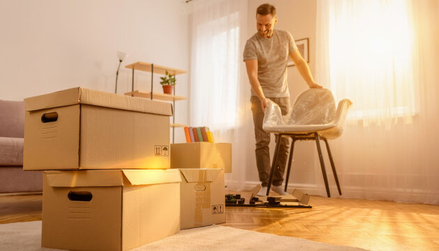 Proceso de un hombre desempacando una silla en una habitaci&oacute;n iluminada por el sol