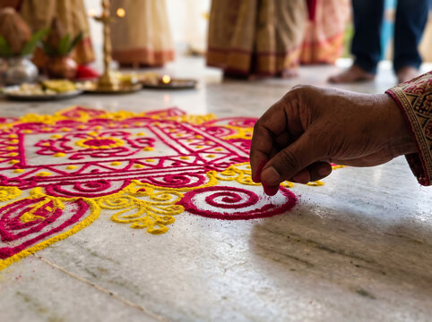 Hand Creating Traditional Colorful Floor Rangoli Pattern for Indian Festival Celebration