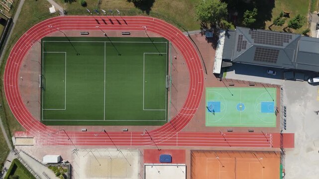 Aerial view of a modern sports stadium with a football pitch and running track.