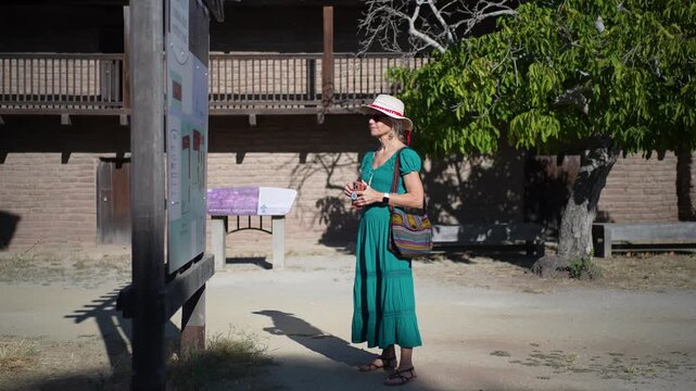 Senior woman enjoys a morning walk through Casa Grande in Sonoma California reading about General Vallejos home and history