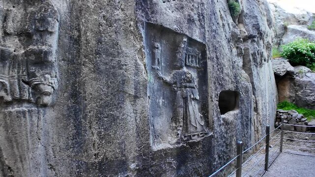 A detailed rock relief carving depicts King Tudhaliya IV under the protection of God Sharruma inside Yazılıkaya&rsquo;s rock sanctuary.