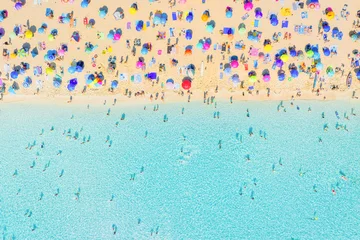 Aerial drone view of people relaxing on a white sand beach under colorful umbrellas. Bright sunny summer vacation scene by turquoise crystal clear sea water. © biletskiyevgeniy