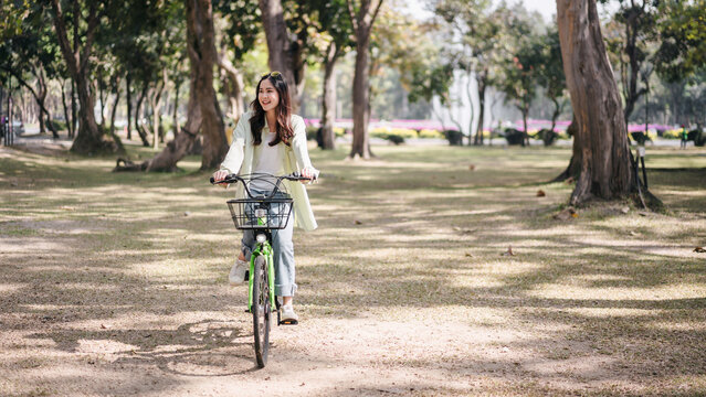 A woman is riding a bicycle in a park