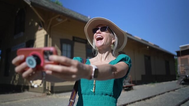 Senior woman smiles as she takes photos at the Depot Museum in Sonoma California while exploring the area on a sunny day