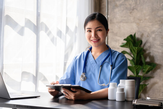 Asian Nurse Woman Medical Professional Healthcare Uniform Stethoscope in Clinic Hospital Writing on Clipboard Paperwork