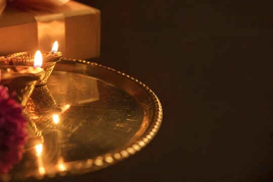 Traditional Diya Lamps Burning on Golden Plate for Diwali Celebration