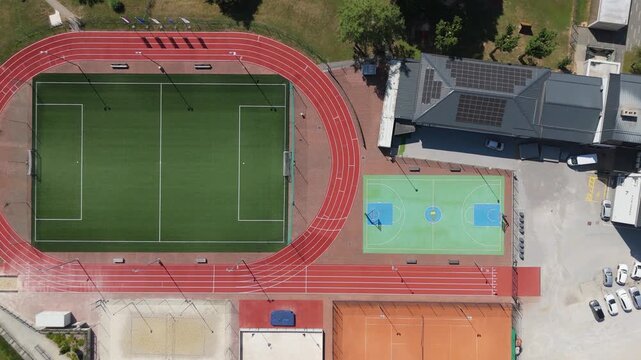 Aerial view of a modern sports stadium with a football pitch and running track.