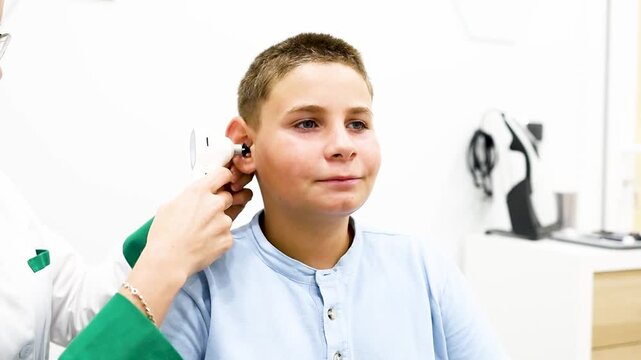 Video of a child undergoing a hearing test with a digital otoscope at a medical center. Concept of hearing problem prevention in young children. Space for an advertisement about hearing.