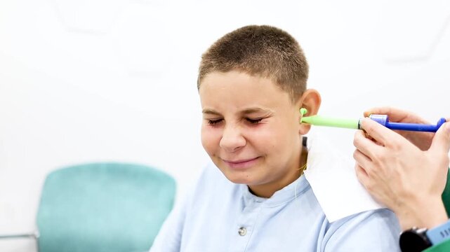 Video of a pre-teen boy having a silicone impression of his ear taken for the manufacture of custom earplugs during an appointment at an ENT clinic.