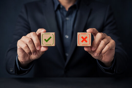 Businessman choosing between right and wrong symbols  representing yes%2Fno decisions  business options  crisis decision-making  and strategic choice concept.