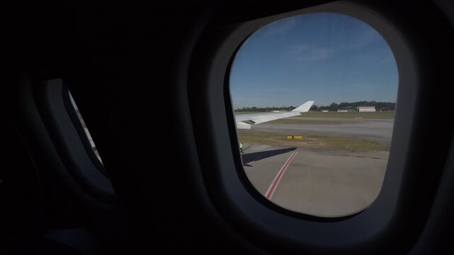 Airplane Window View Over Airport Runway at Midday