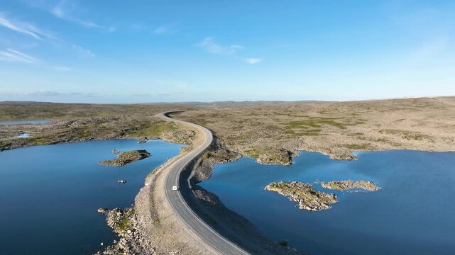 Aerial view of a vehicle driving through the Arctic tundra landscape of the Finnmark in northern Norway
