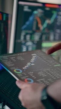 Financial Analytics Dashboard Tablet Displaying Stock Market Statistics Computer Screens. Close-up view of a business analyst holding a digital tablet with trading graphs, percentage charts