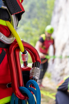 Close-up of locking carabiners on climbing harness with climber blured in background