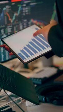 Financial Statistics Data Analytics Tablet Screen Businessman Yearly Revenue Growth Bar Chart. Close-up view of a business analyst holding a tablet displaying annual growth graphs