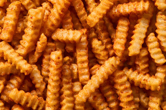 A top view of a stack of crinkle-cut fries, a traditional Cajun dish, serving as the central image.
