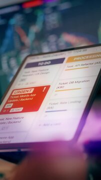 IT Project Management Agile Application Screen Trello Task Kanban Board Urgent Ticket. Close-up view of a business analyst holding a digital tablet displaying project management columns, task progress