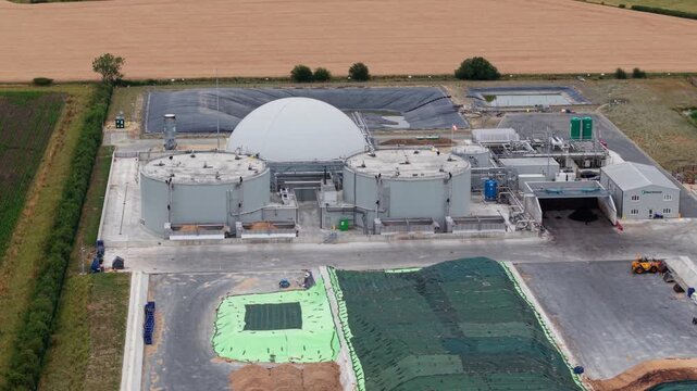 Aerial view of Moor Bio Energy biogas plant with circular digester tanks and central dome surrounded by rural fields in Grantham, England, United Kingdom.