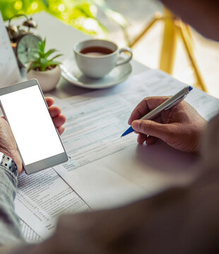 Budget and Tax planning concept. Accountant hand using calculator and review tax forms. Represents personal finance, tax preparation, budgeting, and season to pay tax-vertical image
