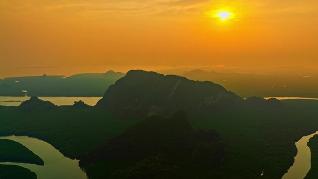 Aerial hyper lapse Beautiful Green Mangrove Wilderness. Beautiful golden sunrise above the mangrove river at Baan Naingob, featuring a scenic heart island and peaceful tropical atmosphere.