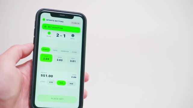 Hand holding smartphone showing sports betting app with live odds close-up 